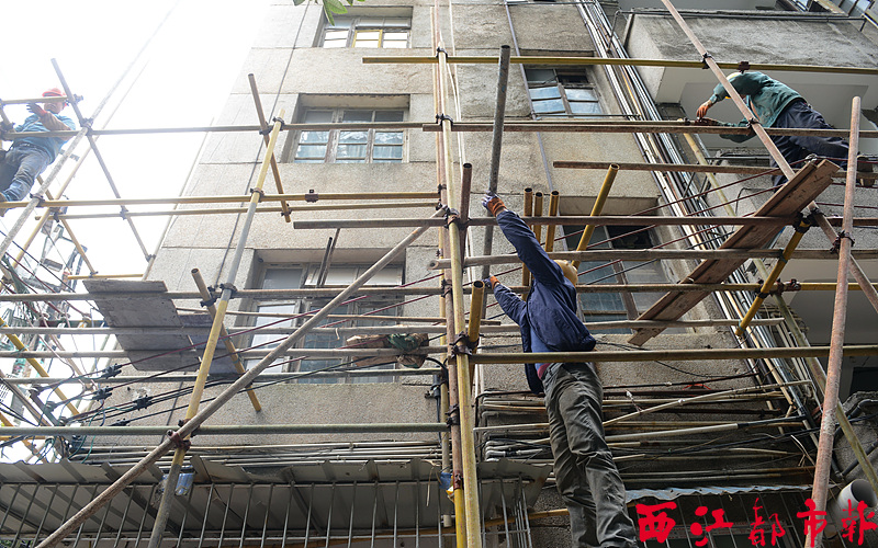 近日，工人正在太和路81號住宅樓搭建腳手架，準備修整翻新大樓外墻。  據了解，東山沖片區棚戶區改造項目計劃在片區范圍內全面實施小街小巷硬化、環境綠化、完善管網線路和排污設施，并對40多幢房屋的外立面進行改造。經過近兩個多月的施工建設，目前部分排污設施進行了更換，多棟住宅樓正在進行外墻整修。 李鴻榮/攝 
