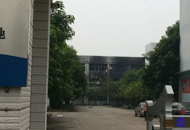 起火廠房外墻已被熏黑，工作人員戴著口罩。 市民王先生攝  